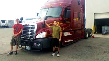 An instructor and his trainee in front of their tractor trailer at Prime Inc headquarters