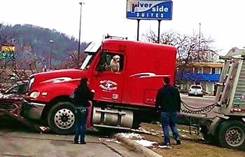 tractor trailer being towed away from the scene of an accident